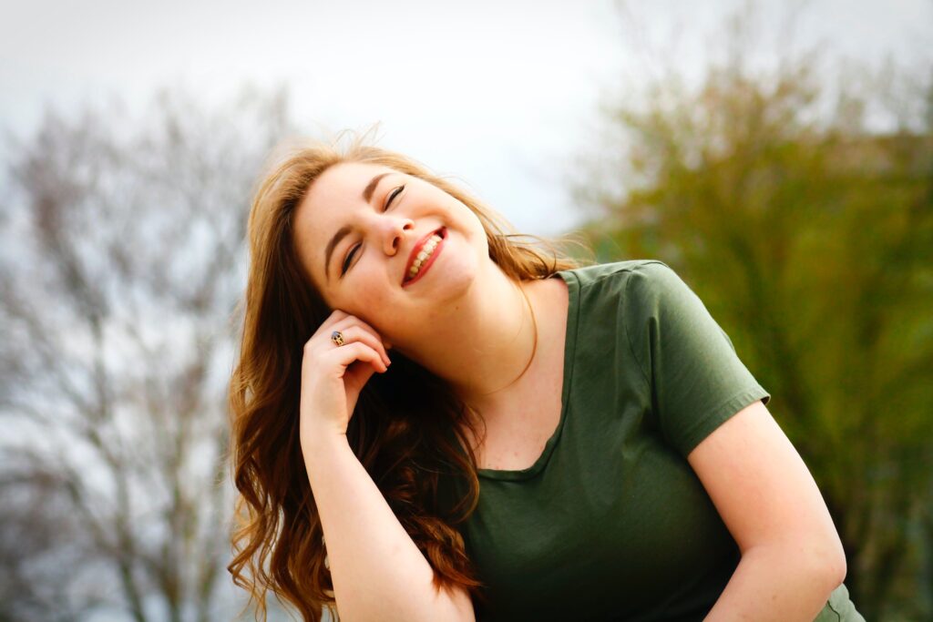 Smiling woman feeling less anxious and more in control of herself as a result of participating on online anxiety counseling.